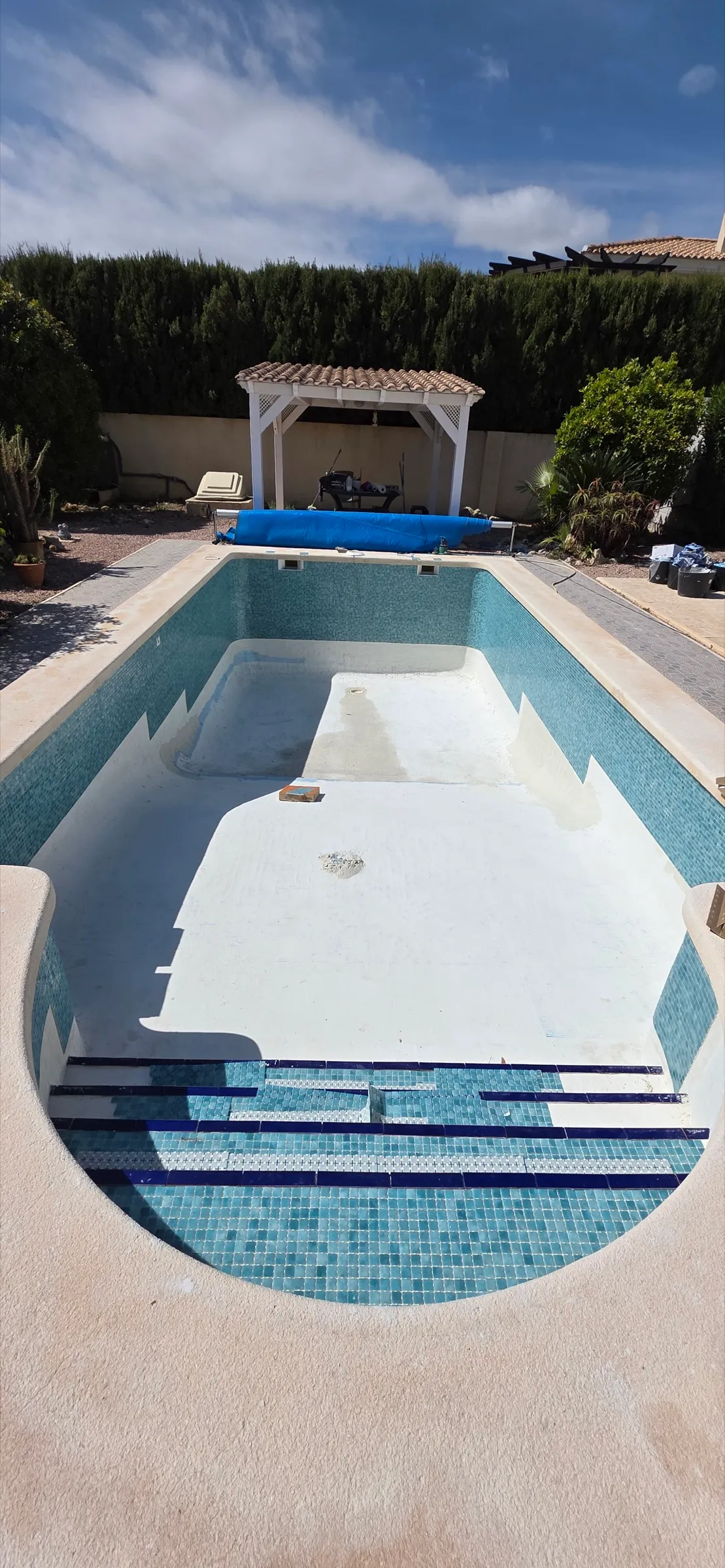 Pool vor der Sanierung, leeres Becken mit altem Belag